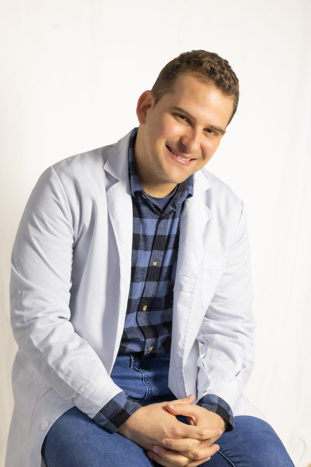 Dr. Miguel Arredondo, médico general en Valdivia, sonriendo con delantal blanco